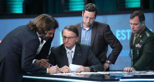 Durante debate eleitoral, o general Mauro Cid orienta e acompanha Bolsonaro. 