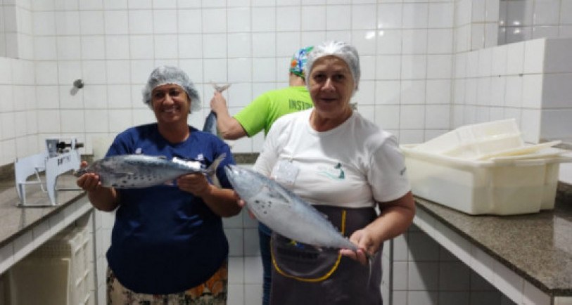 Cooperadas da Arte Peixe, em Atafona, exibindo um dos produtos e matéria prima da empresa. 